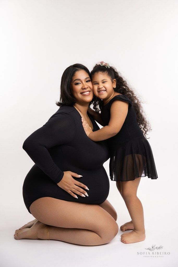mom and daughter pose in matching black bodysuits for maternity photos in oakland nj