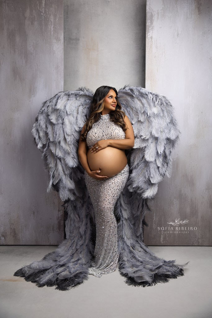 franklin lakes maternity photographer poses mom to be in a stunning set of silver wings showcasing her baby bump.