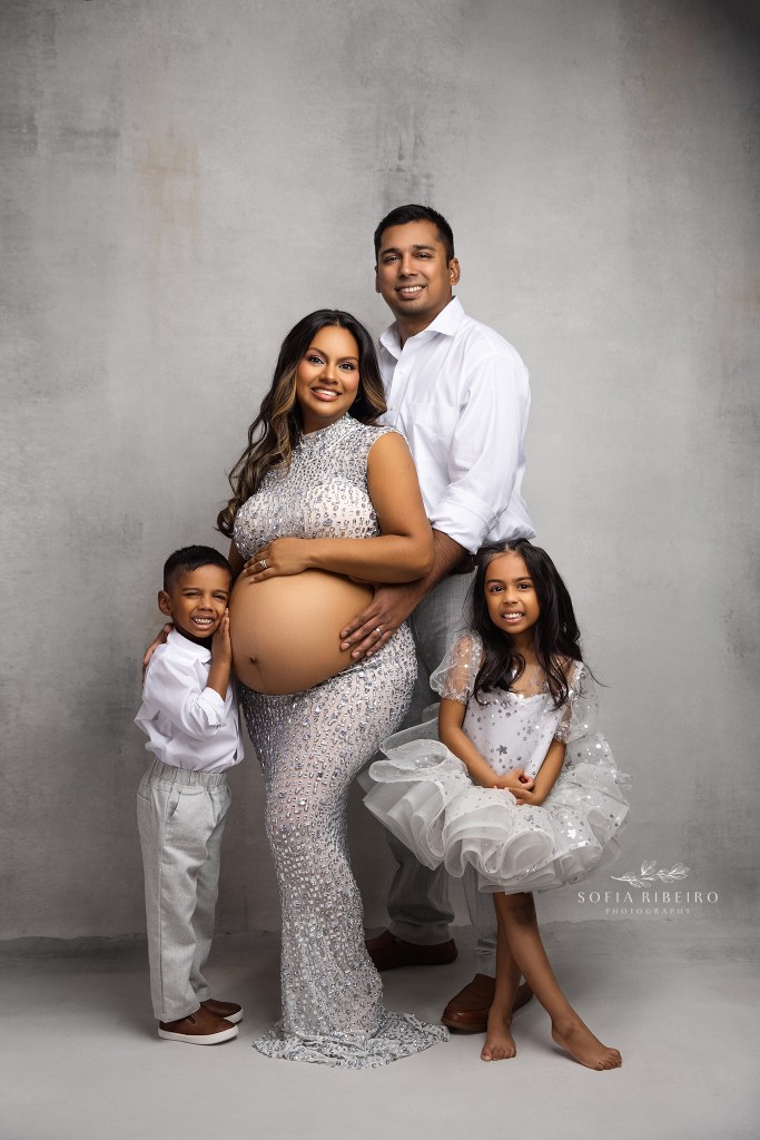 a family of four sparkles in silver with joy at their upcoming new baby for a maternity session in franklin lakes
