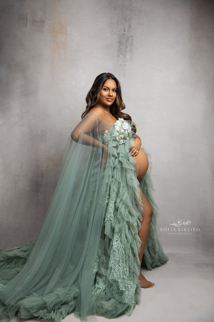 a franklin lakes nj maternity photographer poses mom in a green gown for portraits showcasing her baby bump