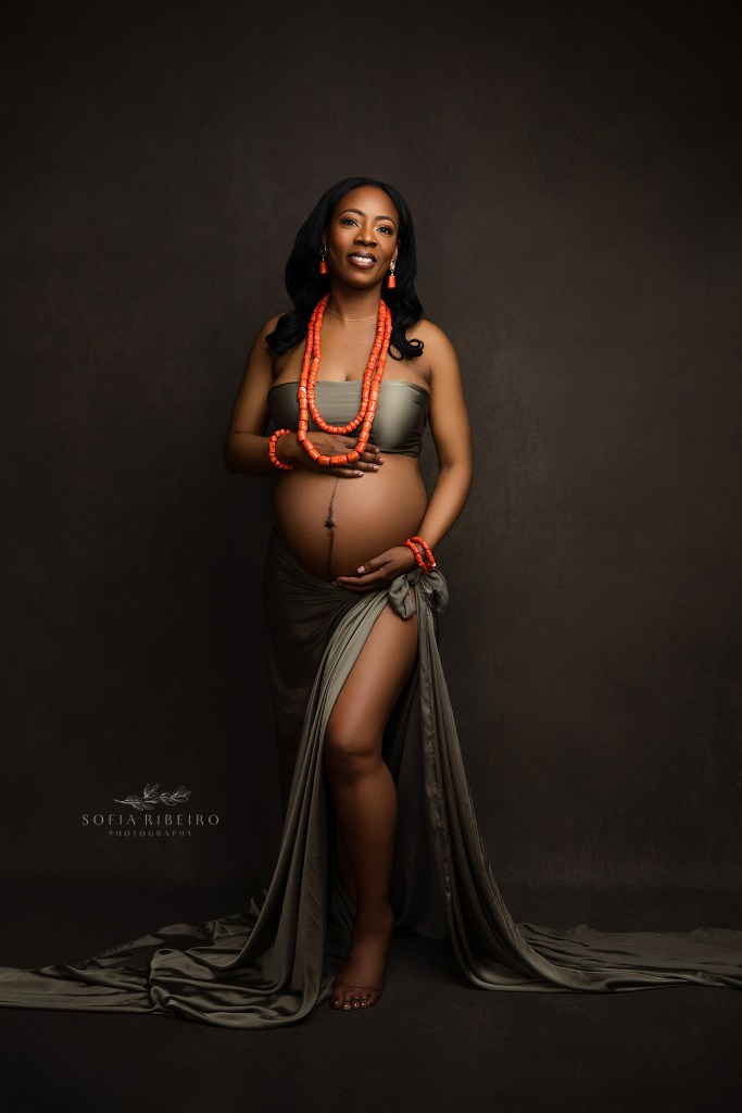 a smiling portrait of an expectant mom in beautiful tones of olive and orange
