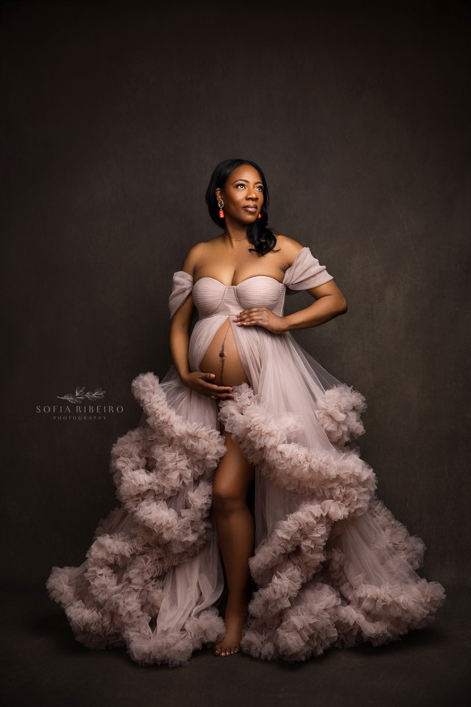 a maternity photographer in franklin nj poses a mom to be in a dramatic tulle gown exposing her baby bump