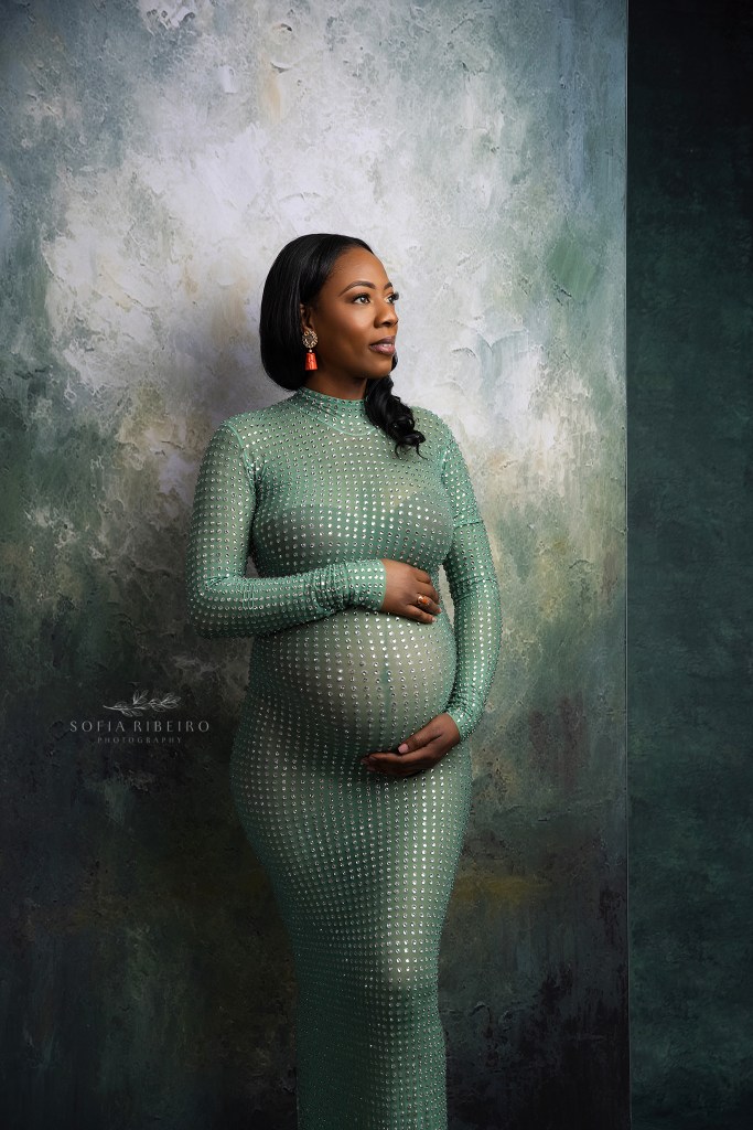 an expectant mom cradles her baby bump in a jeweled dress for a franklin nj maternity photographer