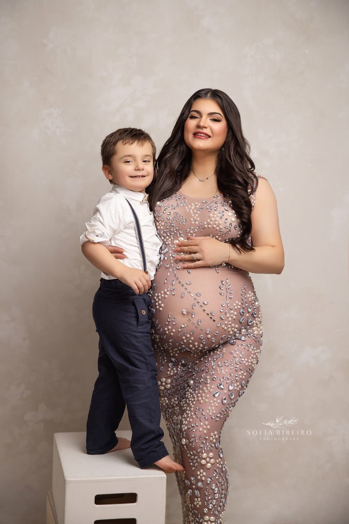 mom and her oldest son cuddle together for a sweet maternity portrait