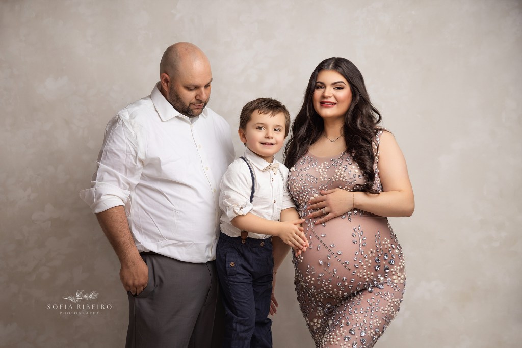 a family portrait of three, soon to be four with mom's glowing belly the focus