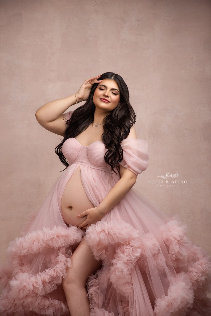 mom to holds her hair away from her face while cradling her baby bump during a photo session with a green brook nj maternity photographer