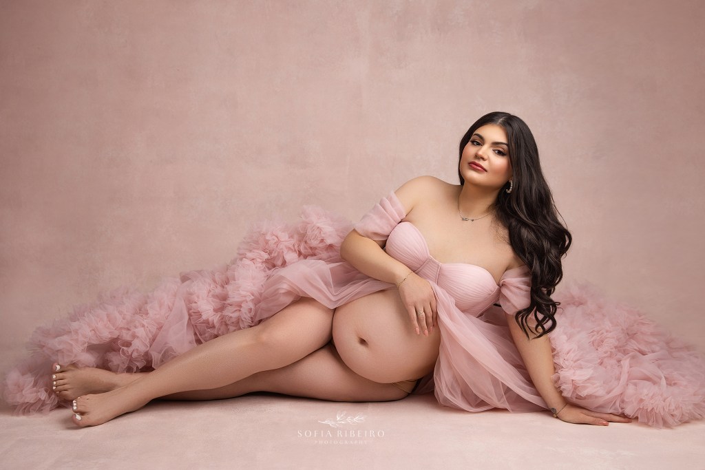 a side lying floor pose emphasizes mom's growing baby bump in a green brook nj maternity photography studio