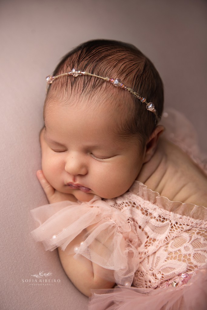a closeup of a newborn baby girl in all her chunky glory dressed in pink