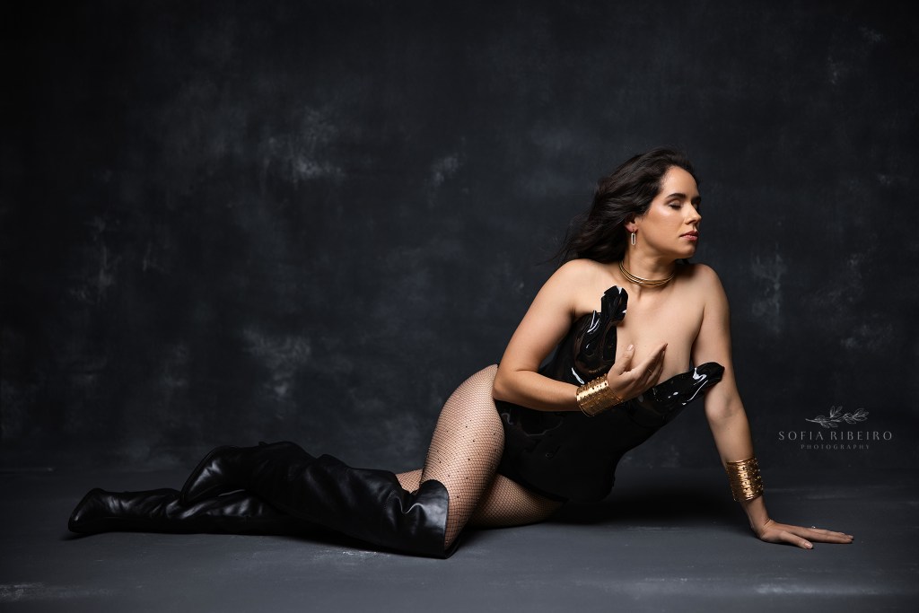 a striking side lying pose showcases an all black look with high boots for birthday portraits