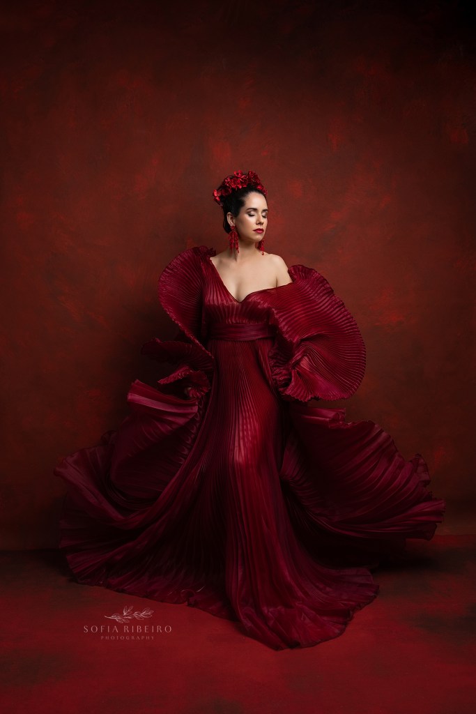 nj headshot and branding photographer creates a dramatic portrait in red with movement in the pleated gown