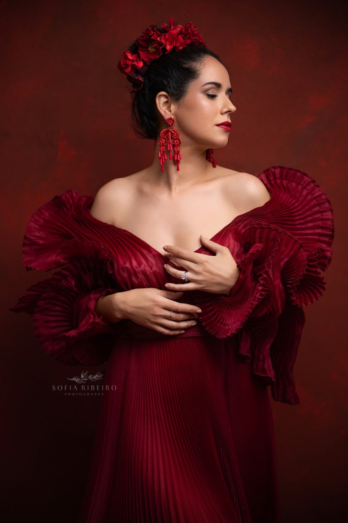 nj branding photographer takes a stunning image in a red pleated gown and earrings