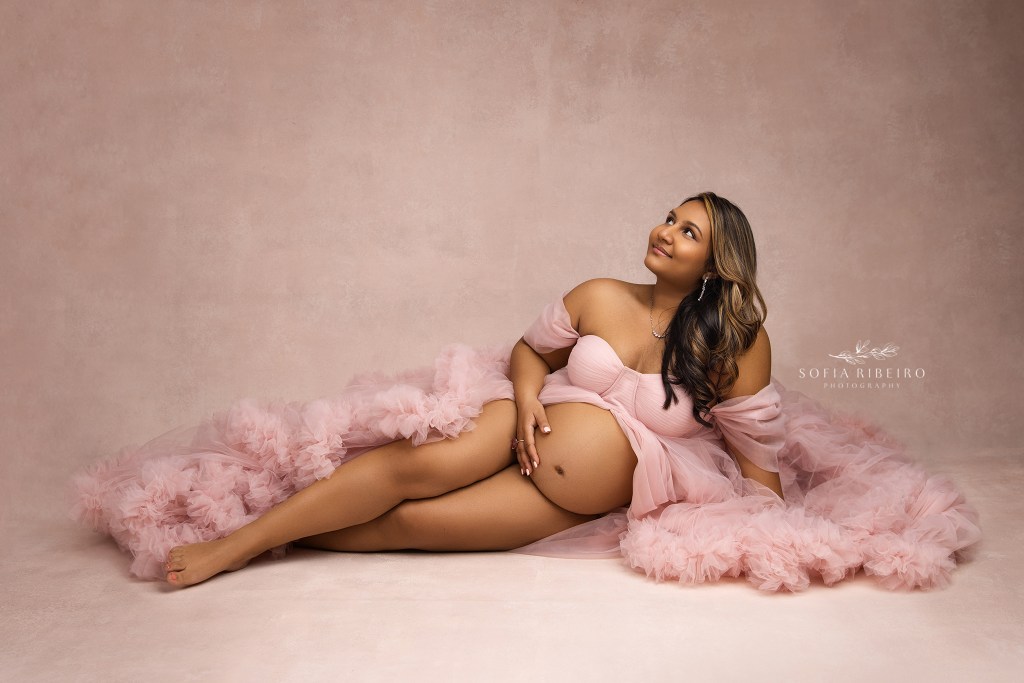 mom to be is a picture of elegance, posed by a nj maternity photographer in an all pink ensemble