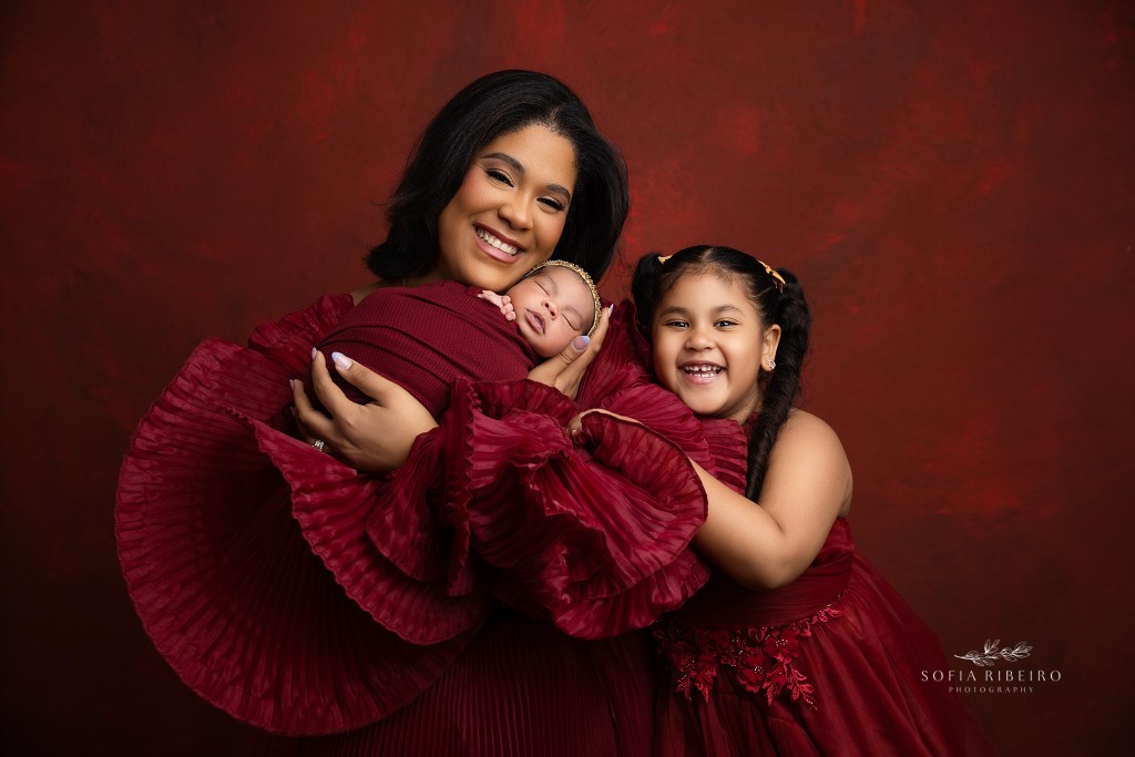 sussex nj newborn photographer captures beaming smiles from mom and daughter while holding their newest addition