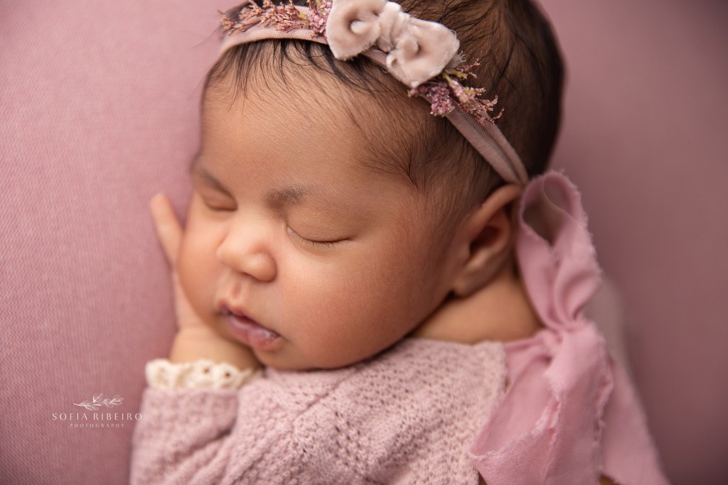 a closeup of a newborn baby girls sweet chubby cheeks