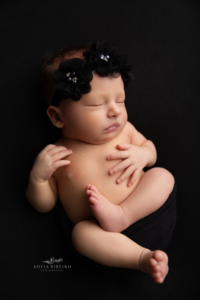 a newborn baby girl posed in black