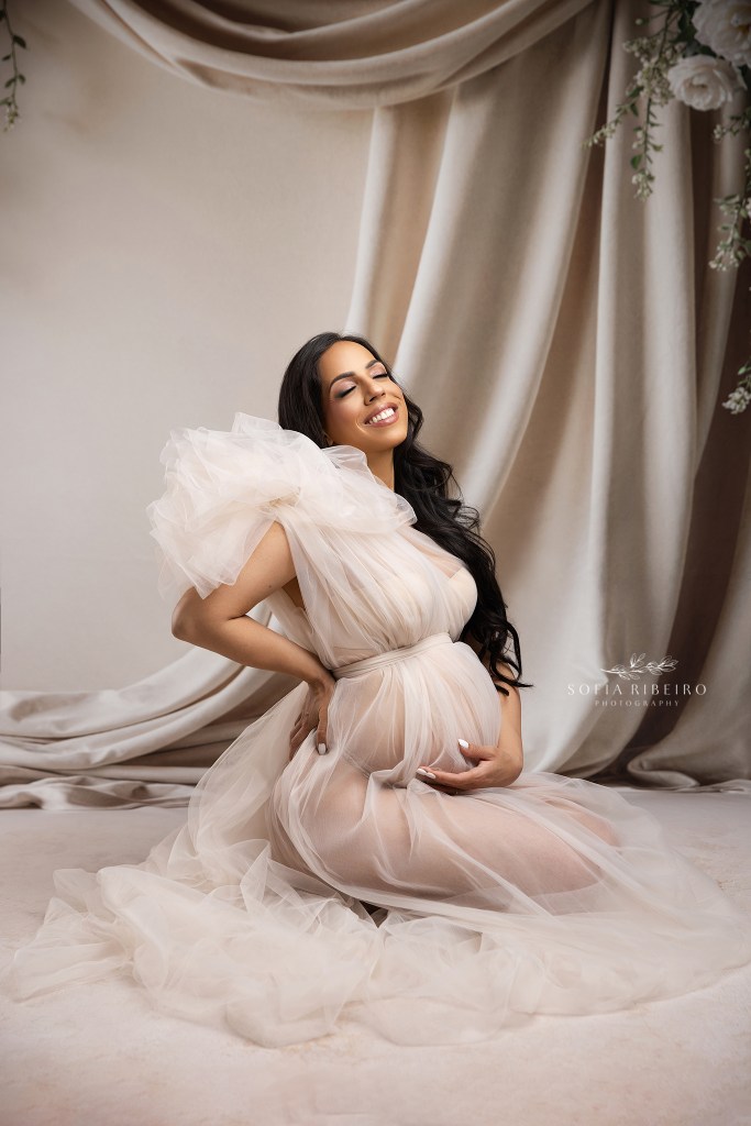 a sheer tulle gown with voluminous shoulders frames moms growing bump in shades of cream