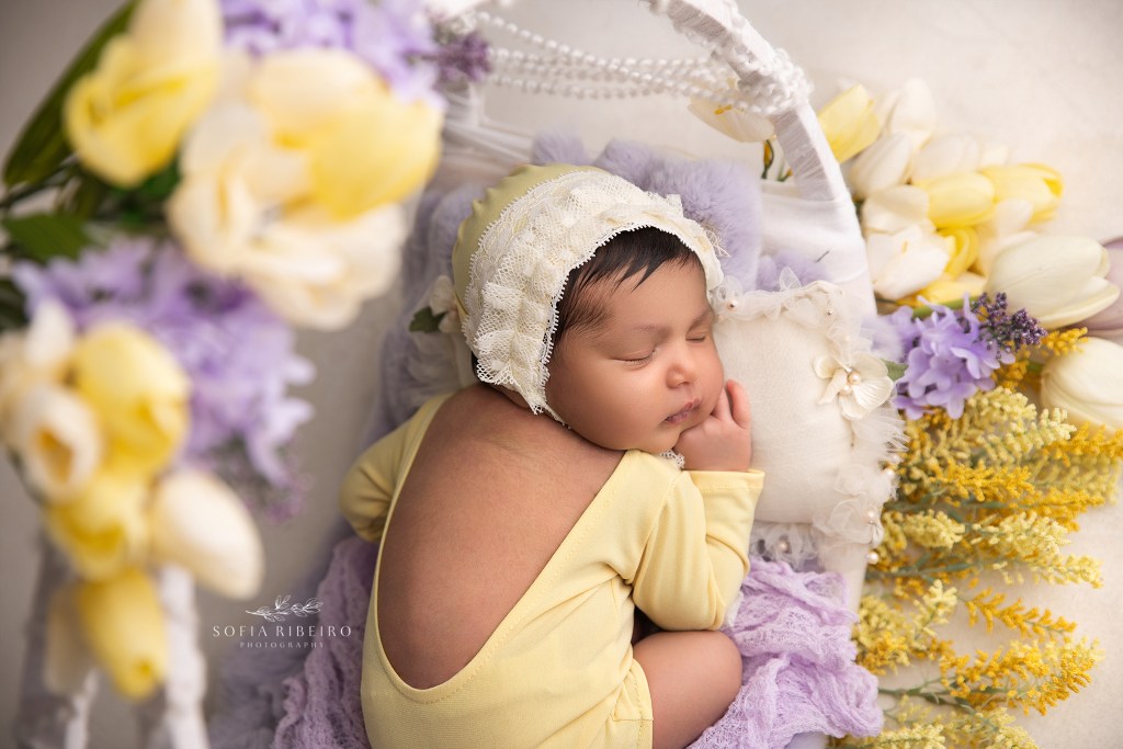baby girl sleeps sweetly in a ring of flowers