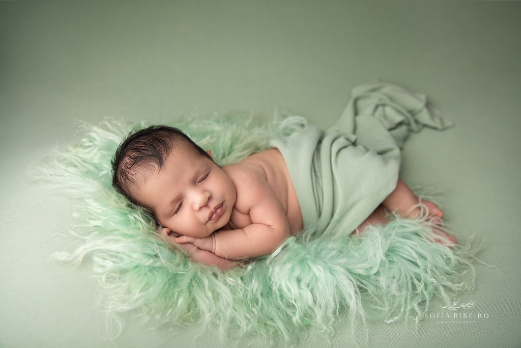 Essex County NJ newborn photography session with baby boy swaddled in sage green tones.