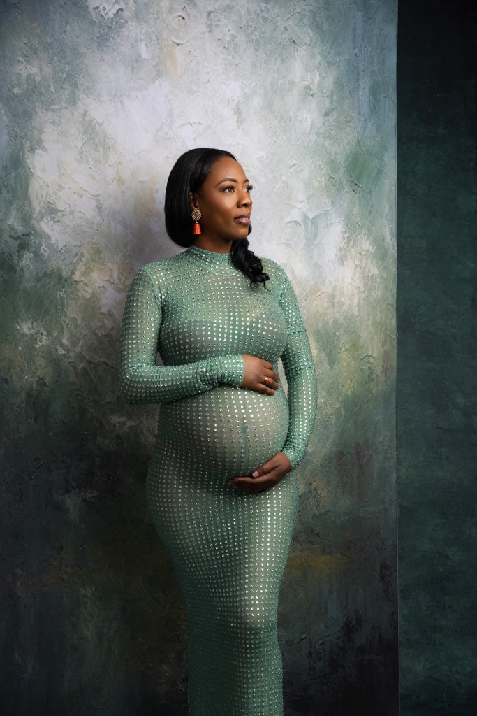 a gorgeous portrait of an expectant mom cradling her belly in tones of green in an nj maternity photography studio