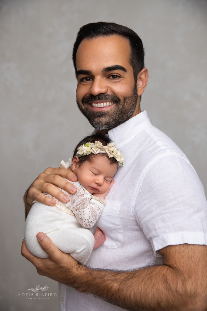 Dad smiling at his newborn daughter during their studio newborn session in nj