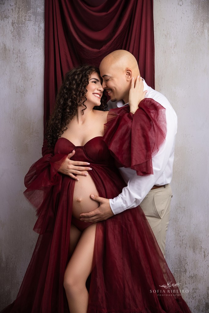 mom and dad share a sweet cuddle together during their maternity session