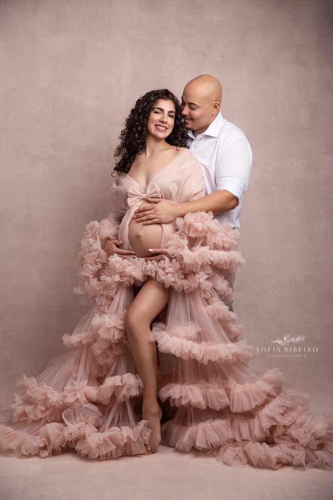 maternity portrait capturing a loving embrace between mom and dad in shades of pink