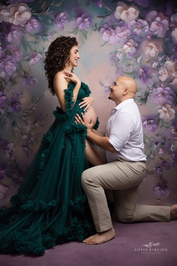 mom and dad share a tender moment snuggling the baby bump for a portrait.