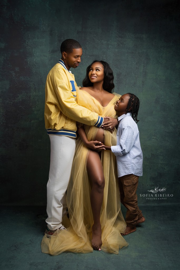 a happy family embraces mom's baby bump during maternity portraits in morris plains nj