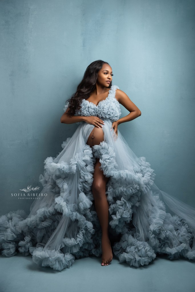 mom to be poses during a maternity session in a morris plains nj maternity studio in an elegant blue gown