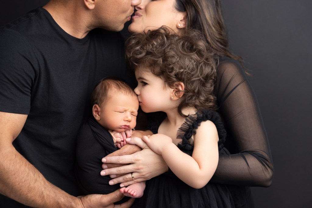 a closeup of baby and family details against a black backdrop in a nj newborn photography studio