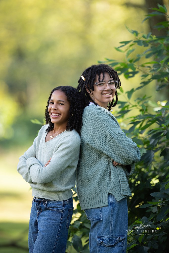 cranford family photographer captures two sisters in greenery outdoors