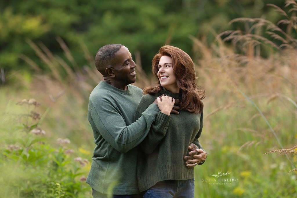 cranford nj family photographer captures mom and dad in a sweet pose together in matching green sweaters in a local park