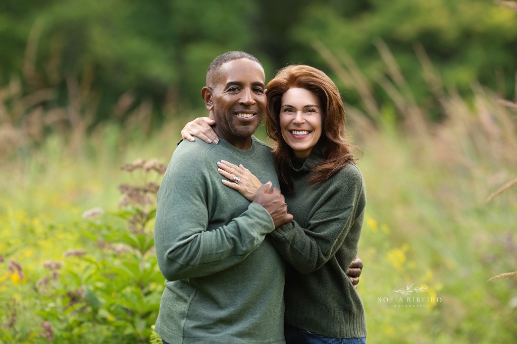 cranford nj family photographer captures mom and dad in a sweet pose together in matching green sweaters in a local park