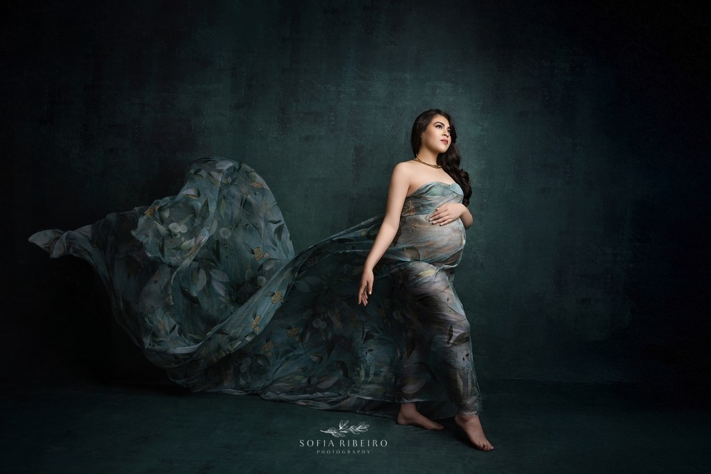 an elegant fabric toss and sweet baby bump are the focus of this maternity portrait