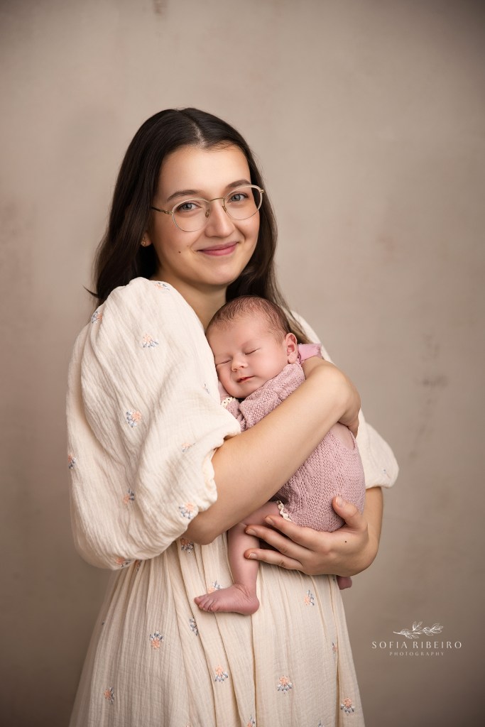 mom snuggles her baby girl sweetly during her newborn session