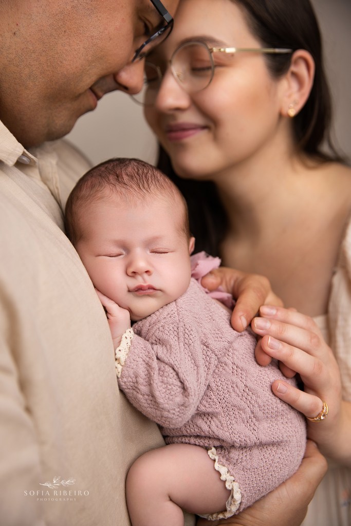 a closeup of newborn baby girl in parents hands
