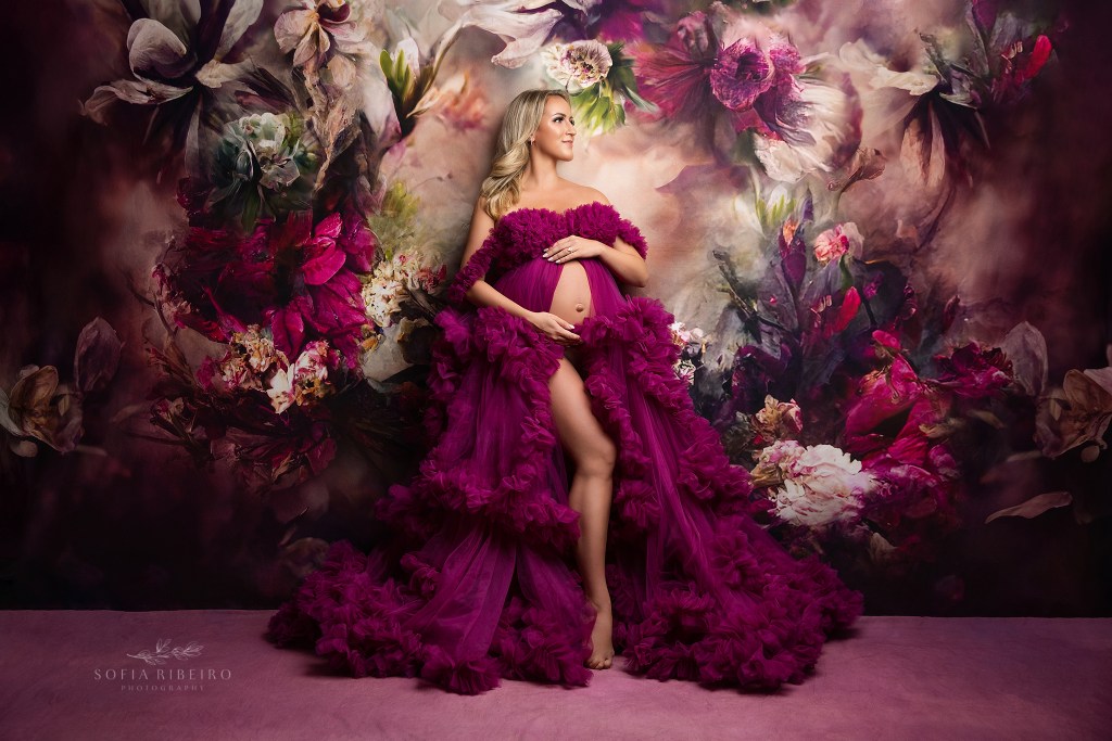 a pregnant mom is a portrait of perfection against a floral backdrop shot by a ridgewood nj maternity photographer