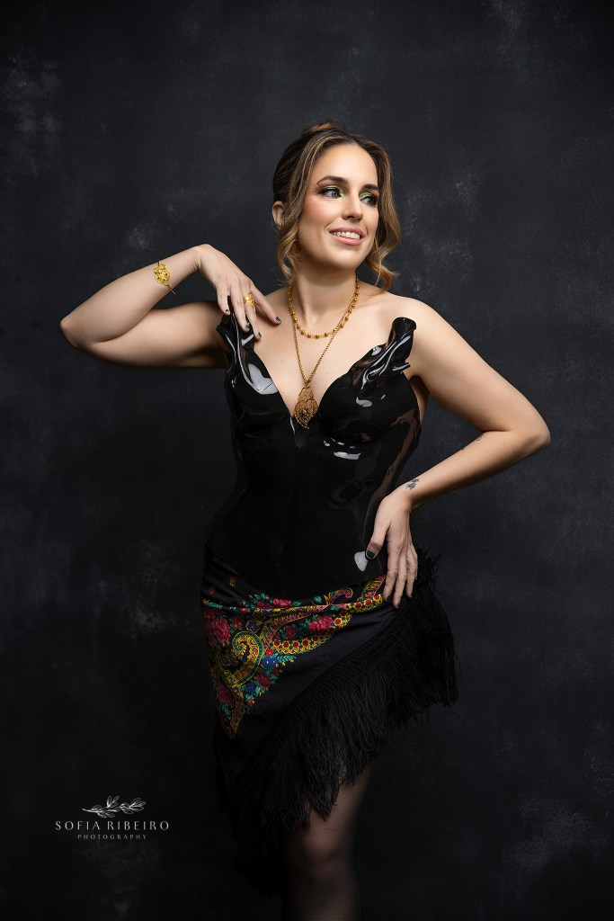 a portrait honoring portugal, with gold coracao de viana jewelery and typical portuguese scarves, set against a black bodice and dramatic warm lighting