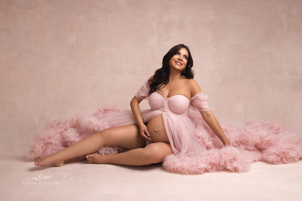 nj maternity photographer captures mom in a fluffy pink tulle gown cradling her belly
