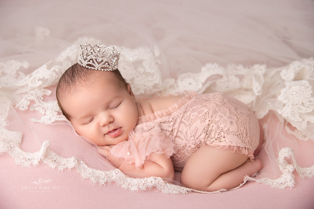 newborn baby girl is posed against mom's bridal veil in budd lake nj