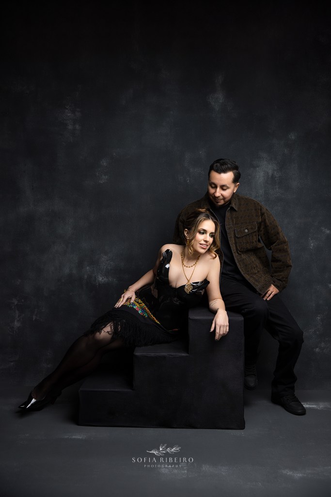 a 40th birthday session with a couple against a black backdrop