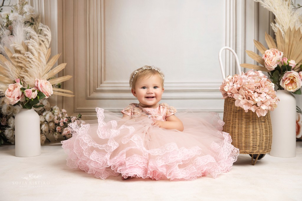 baby sits in a pink dress during a mother daughter photoshoot in an nj studio
