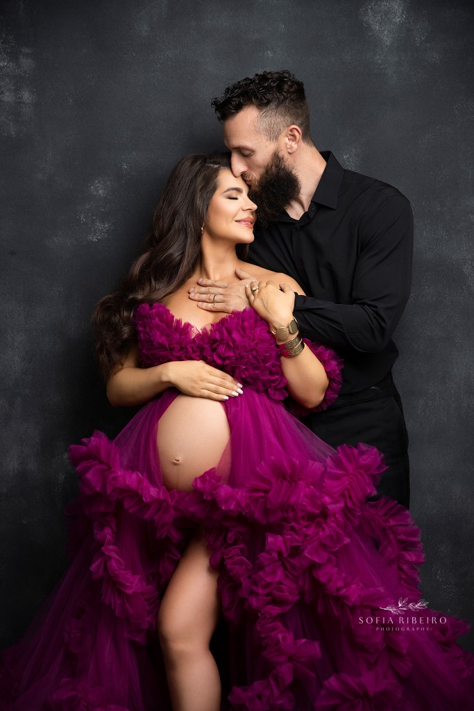 south jersey maternity photographer captures a glowing expectant couple in an intimate pose against a black backdrop