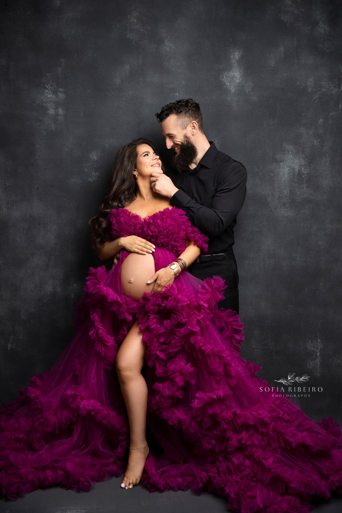 dad cradles mom's face in a loving gesture during a maternity session in studio