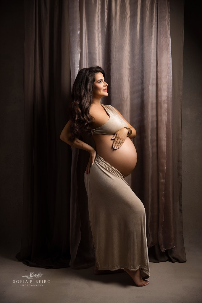 a side profile of mom to be with a cutout dress shows off her gorgeous baby bump