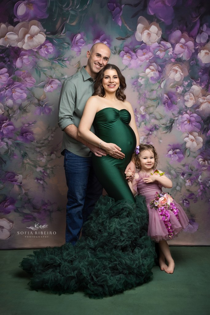 family maternity photography in studio against a floral backdrop