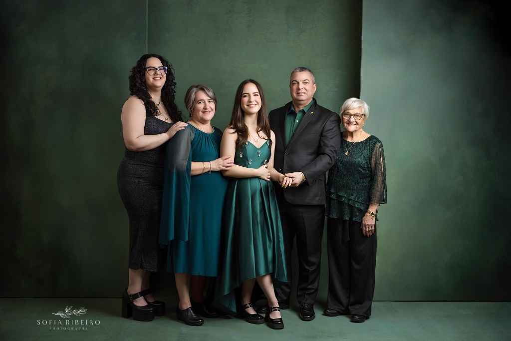 a posed family portrait against a green backdrop