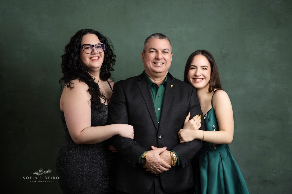 dad takes a photo with both of his daughter for portraits celebrating his youngest's sweet 16