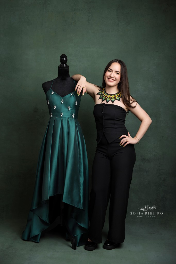 teen girl poses with her sweet 16 gown on a mannequin before a photo session