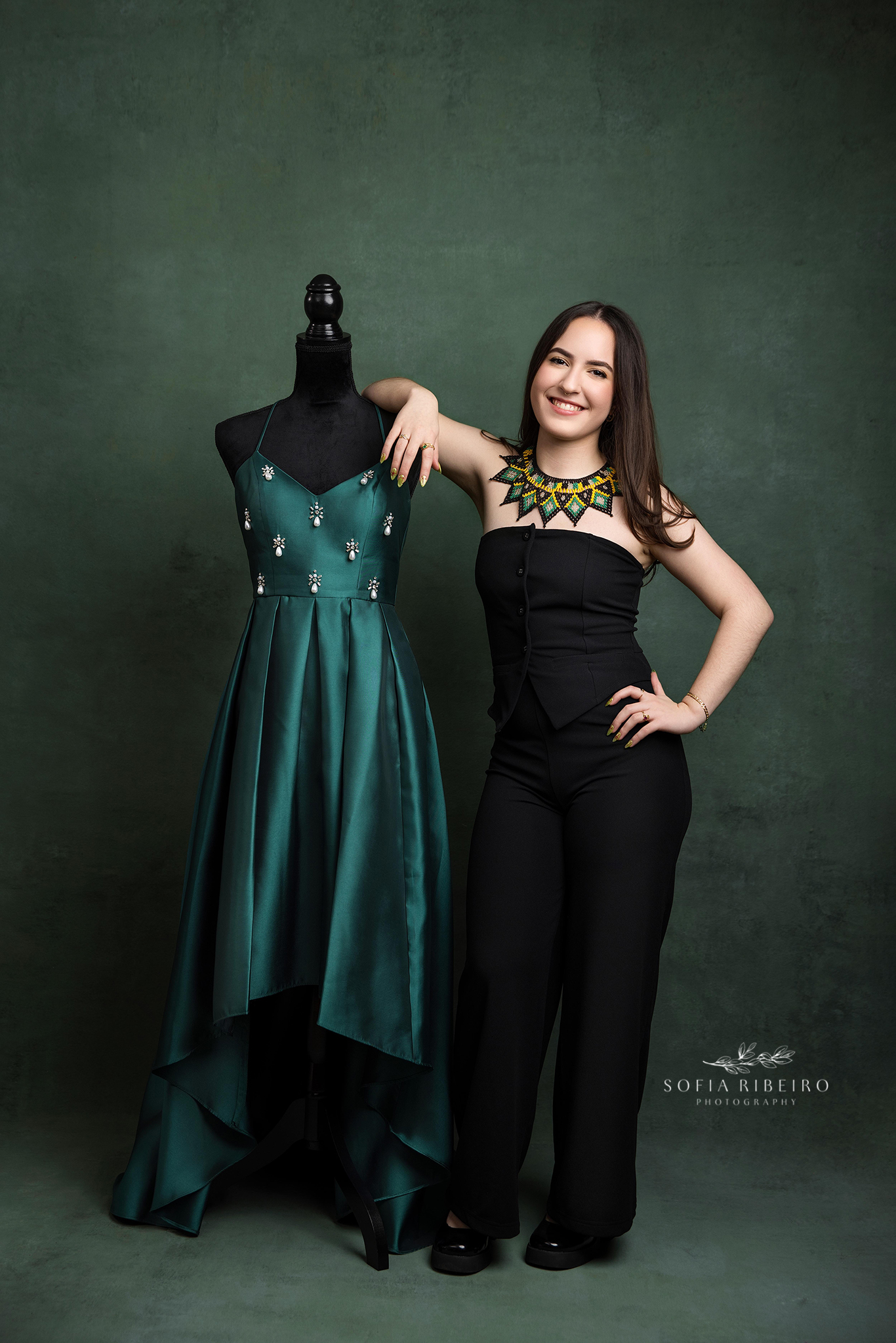teen girl poses with her sweet 16 gown on a mannequin before a photo session